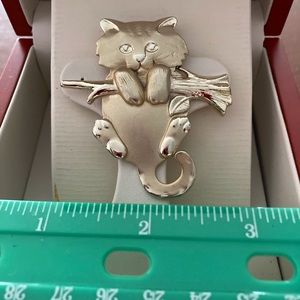 Adorable gold toned pin of a kitten hanging from a branch.